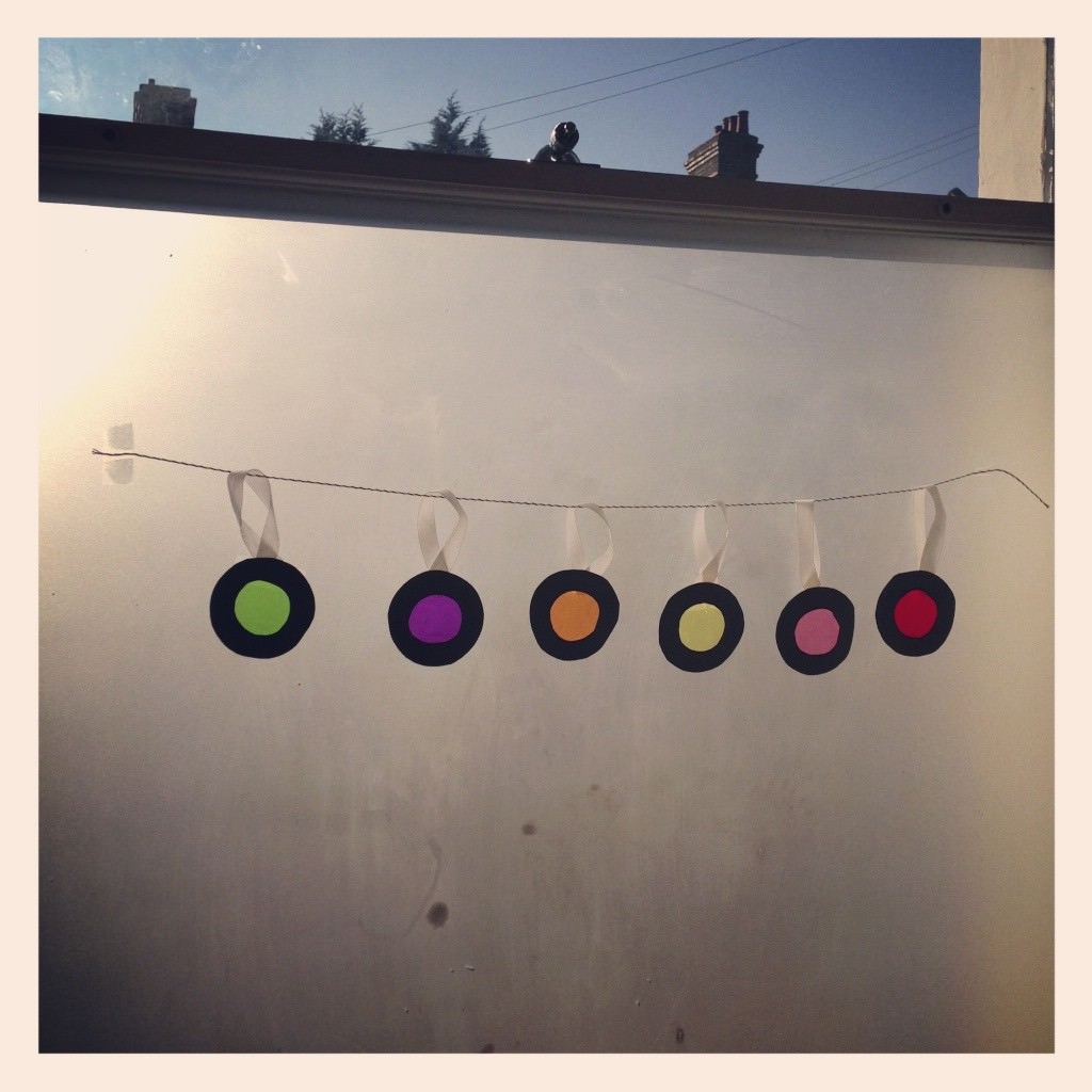 sweet wrapper baubles hanging in a window