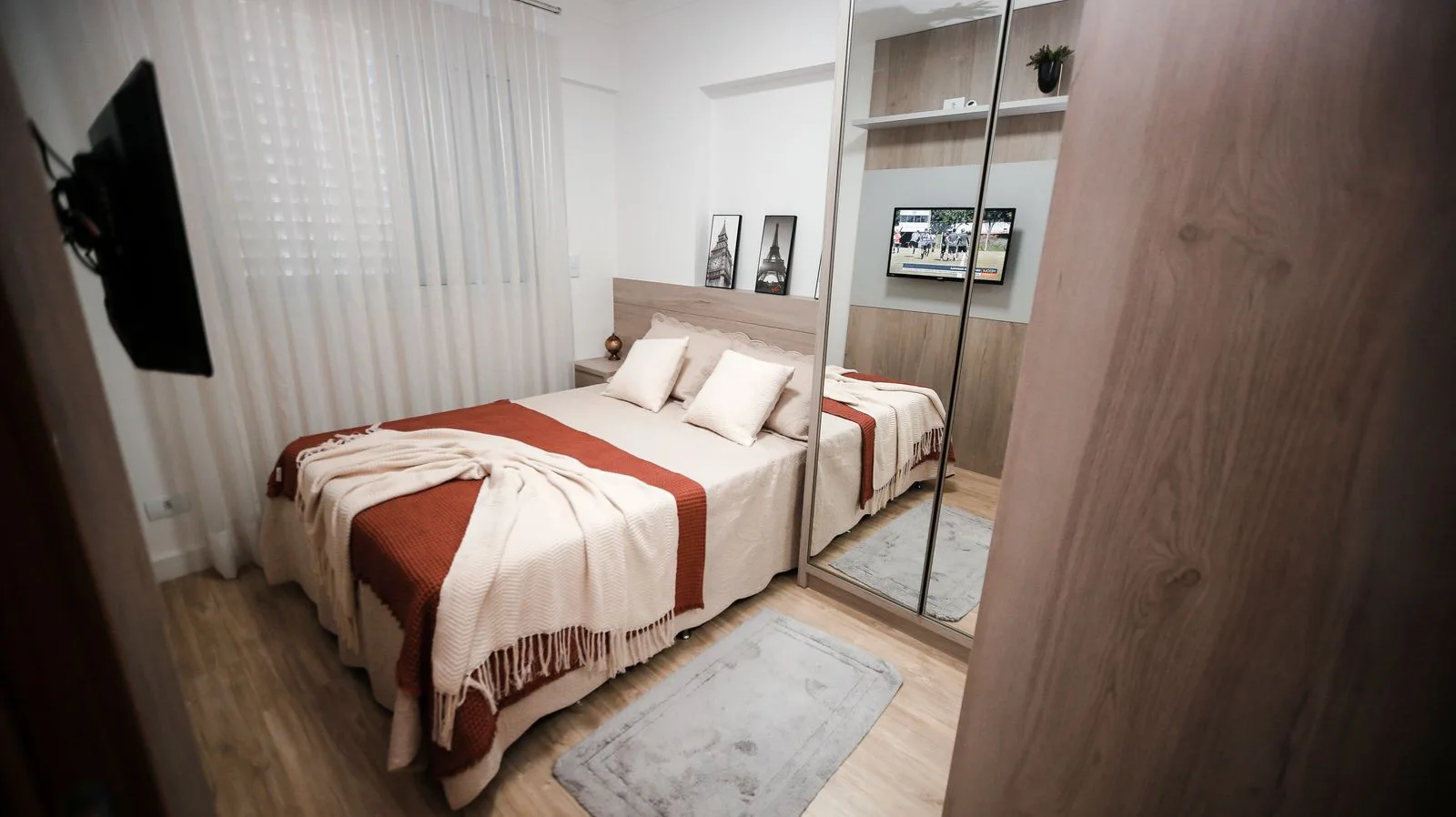 A pale bedroom with pillows and a striped bed covering