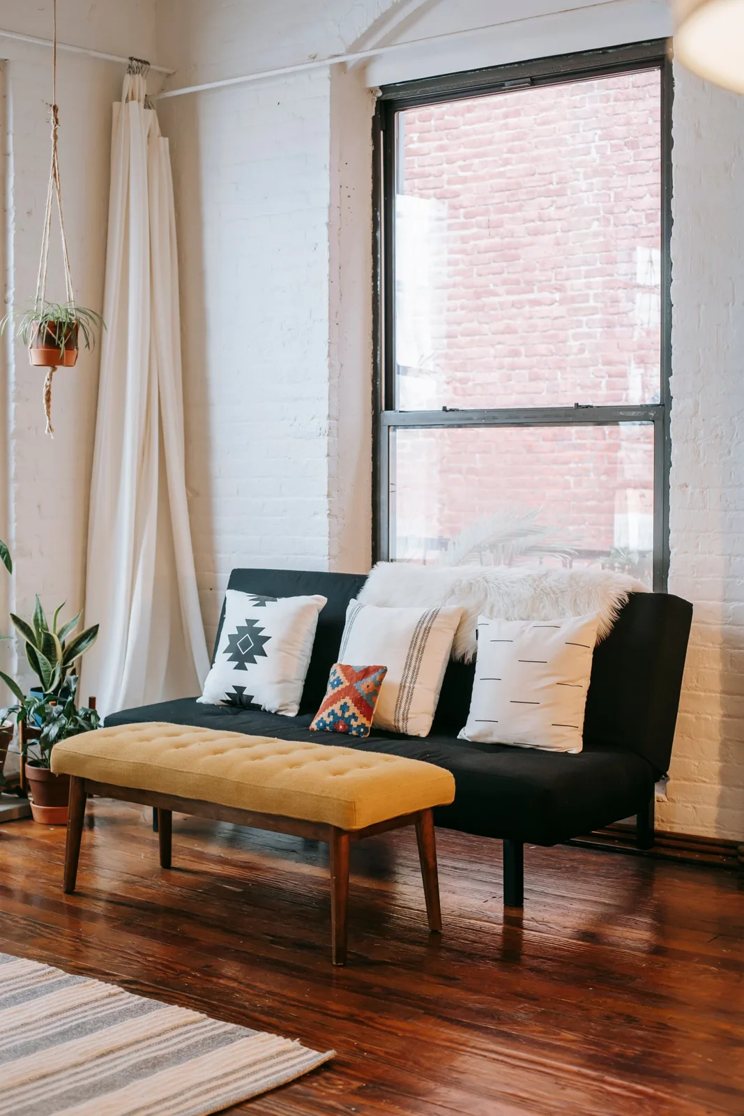 Sunlit living room with sofa and cushions