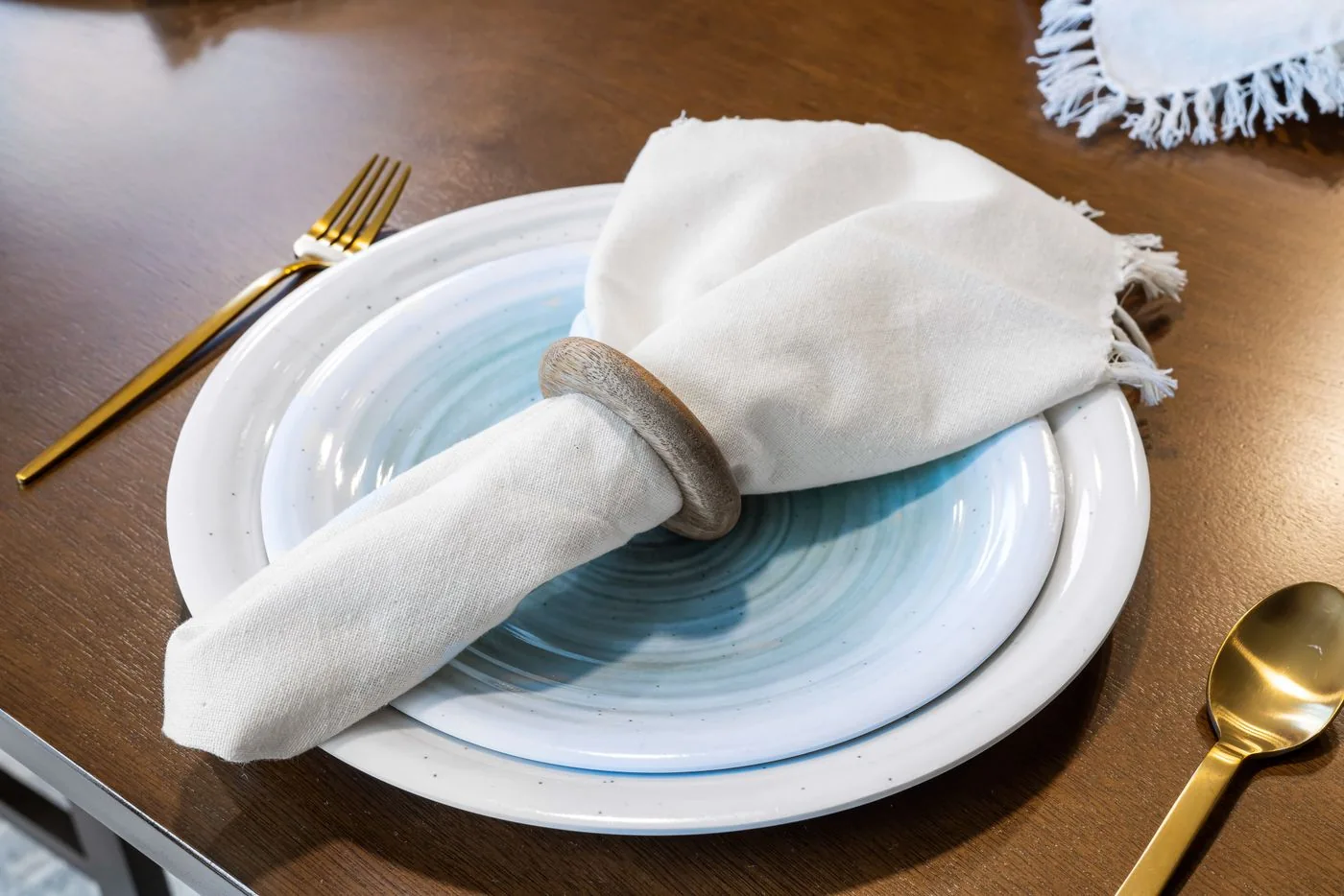 Pale plates and a light napkin with gold-toned cutlery