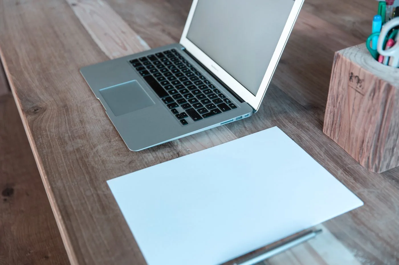 Simple desk with laptop paper and pen