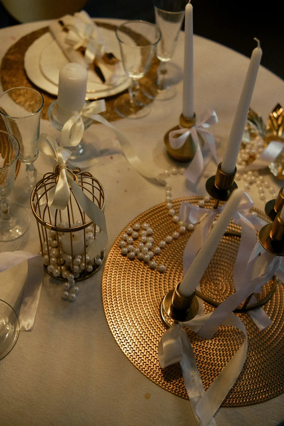 Candles, ribbon, glassware and small decorations arranged on a table