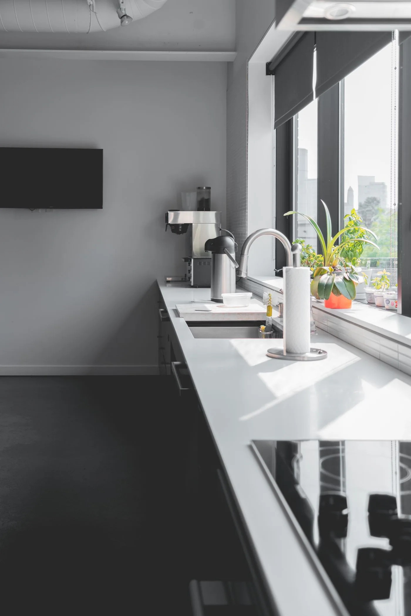 A kitchen counter and sink beside a large window