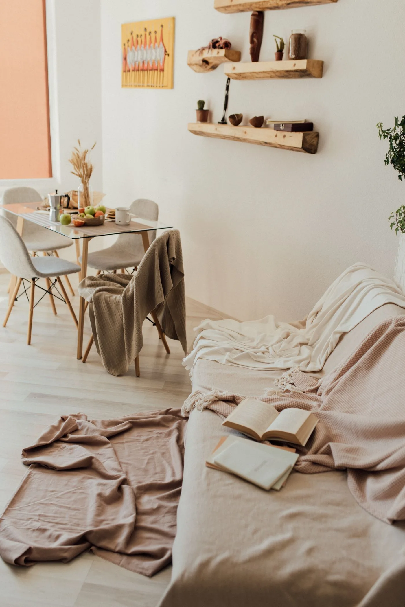 A pale living area beside a dining table and chairs