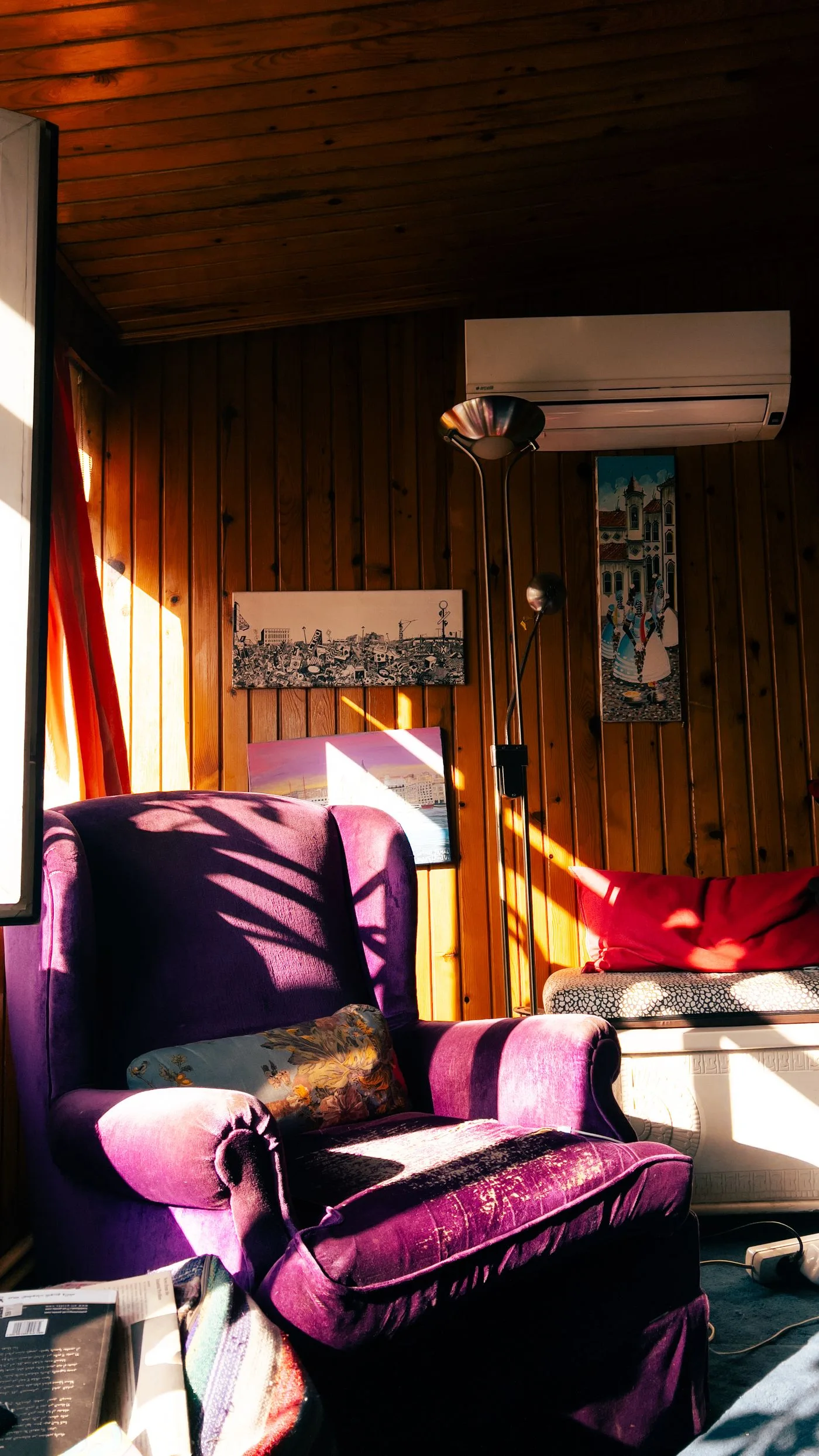 A purple chair in sunlight beside wood-paneled walls