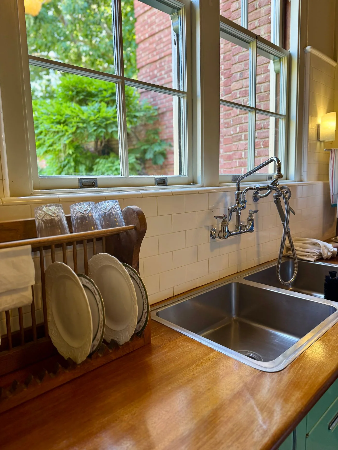 A double kitchen sink with a dish rack beneath a window